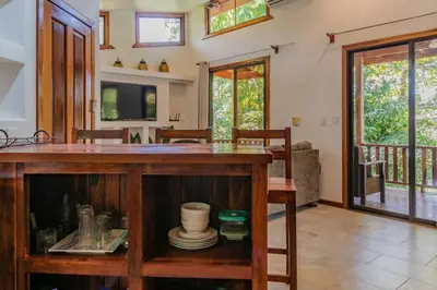 a kitchen and living room with a counter and a tv at Surfside Apartments - Mal Pais in Mal País