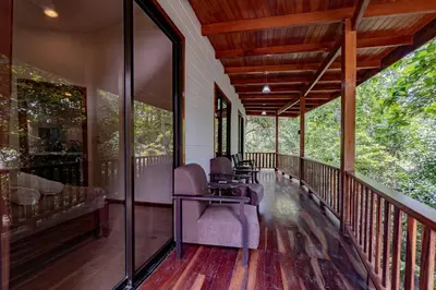 a screened in porch with chairs and a table at Surfside Apartments - Mal Pais in Mal País