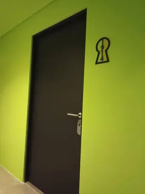 a black door with a lock on a green wall at Secrt 1914 in San José