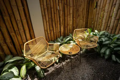 three chairs and a table in front of a fence at Suwa Villa Arenal in Fortuna