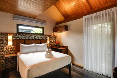 a bedroom with a bed and a window at Suwa Villa Arenal in Fortuna