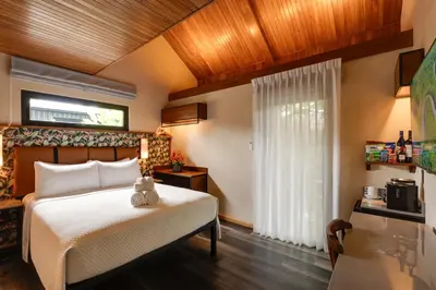 a bedroom with a white bed and a window at Suwa Villa Arenal in Fortuna