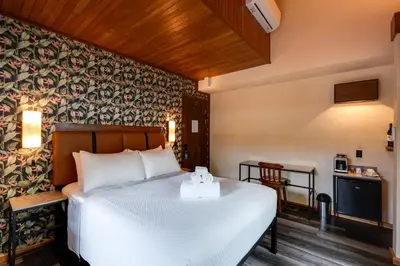 a bedroom with a bed with a white bedspread at Suwa Villa Arenal in Fortuna