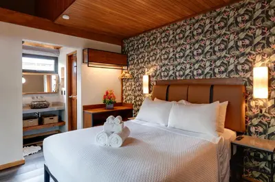 a bedroom with a bed with two towels on it at Suwa Villa Arenal in Fortuna