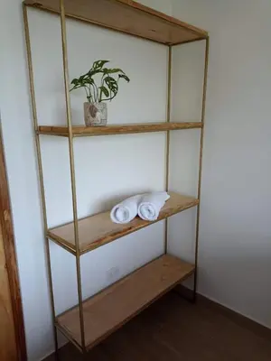 a book shelf with towels and a plant on it at Laurel Jungle & Ocean in Santa Teresa Beach