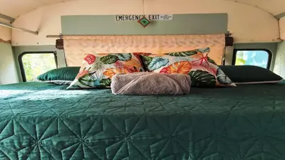 a bed in an rv with a green comforter at Nanku Nimbu Casa-Bus equipada cerca de playas in Sámara