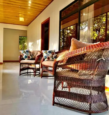 a living room with wicker chairs and a couch at Villa El Nido Monteverde in Monteverde Costa Rica