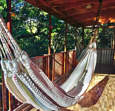 two hammocks on a deck with trees in the background at Villa El Nido Monteverde in Monteverde Costa Rica