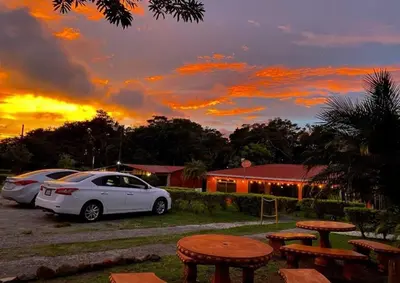 a white car parked in a parking lot with a sunset at Villa El Nido Monteverde in Monteverde Costa Rica