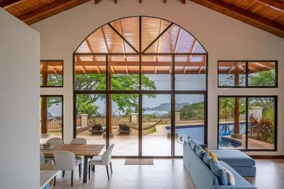 an open living room with a large window and a pool at Casa Carrillo in Buenos Aires