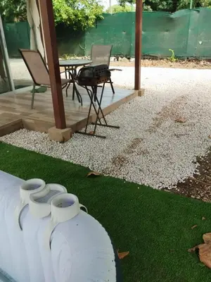 a patio with a table and some vases on the grass at Casa espejo in Potrero