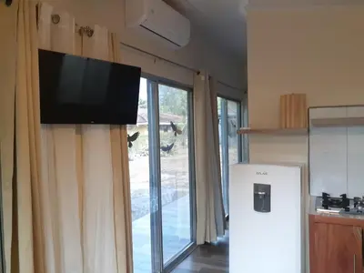 a kitchen with a refrigerator and a television on a wall at Casa espejo in Potrero