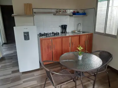 a small kitchen with a table and a refrigerator at Casa espejo in Potrero