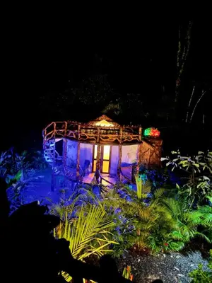 a small house with blue lights in a garden at El Valle Mineral Springs in San Ramón