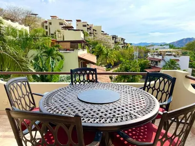 a table and chairs on a balcony with a view at Rooftop Sunset Cove in Liberia