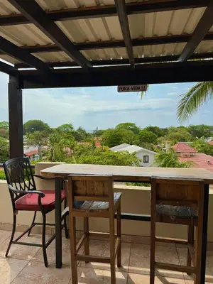 a table and chairs on a balcony with a view at Rooftop Sunset Cove in Liberia