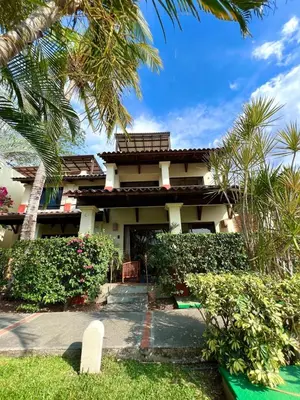 a house with a palm tree in front of it at Rooftop Sunset Cove in Liberia