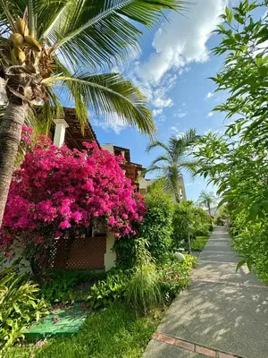 a walkway next to a building with pink flowers at Rooftop Sunset Cove in Liberia