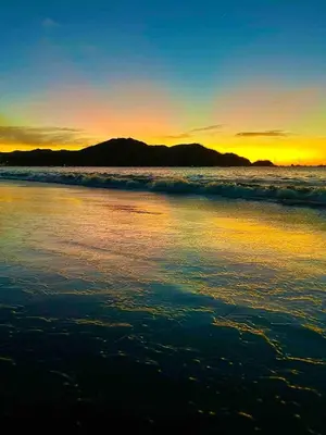 a sunset on the beach with the ocean at Rooftop Sunset Cove in Liberia