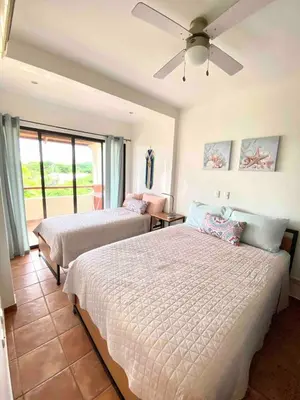 a bedroom with two beds and a ceiling fan at Modern Condo with a Rooftop Patio in Liberia