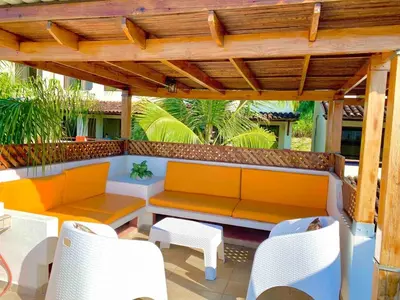 a patio with a bench and chairs under a wooden pergola at Modern Condo with a Rooftop Patio in Liberia