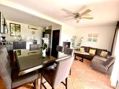 a dining room and living room with a dining table at Modern Condo with a Rooftop Patio in Liberia
