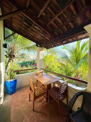 a patio with a wooden table and chairs on a balcony at Stylish & Comfortable Condo with Balconies in Liberia