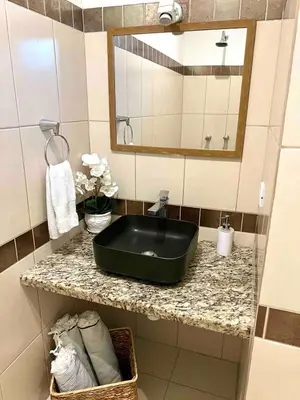 a bathroom with a black sink and a mirror at Stylish & Comfortable Condo with Balconies in Liberia