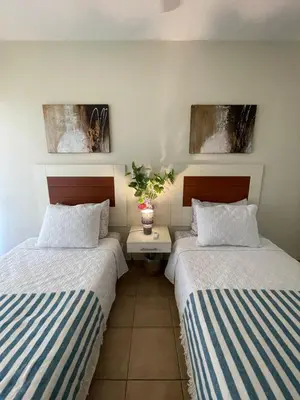 two beds sitting next to each other in a room at Stylish & Comfortable Condo with Balconies in Liberia