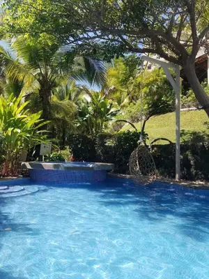 a swimming pool with blue water in a yard at Turtle's Nest Condo in Liberia