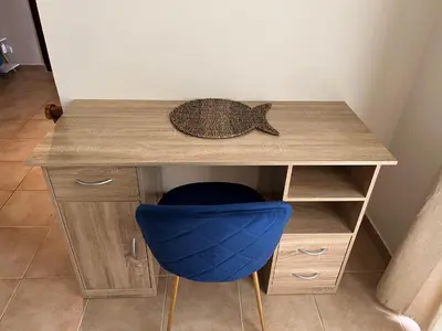 a wooden desk with a blue chair under it at Turtle's Nest Condo in Liberia