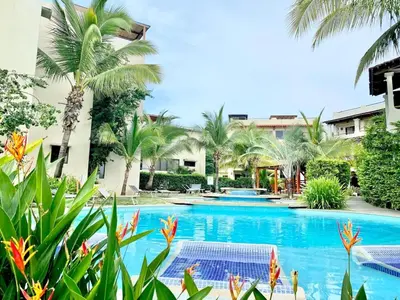 a pool at a resort with palm trees at Turtle's Nest Condo in Liberia