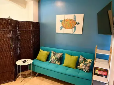 a blue couch with yellow pillows in a room at Turtle's Nest Condo in Liberia