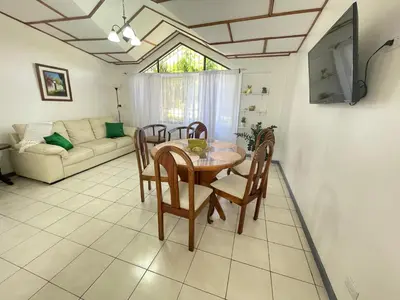 a dining room with a table and chairs and a couch at 3 Min from SJO airport Kaeli in Alajuela City