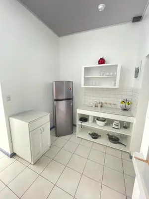 a kitchen with a refrigerator and a tiled floor at 3 Min from SJO airport Kaeli in Alajuela City