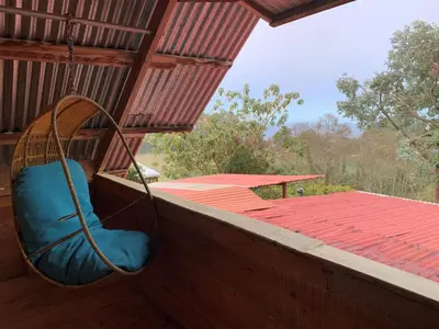 a blue chair sitting on a porch with a roof at Cabaña Mamá Elia in Trinidad