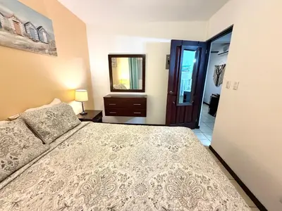 a bedroom with a bed and a mirror at Cocomarindo Breeze Condo and Amazing Pool in Coco