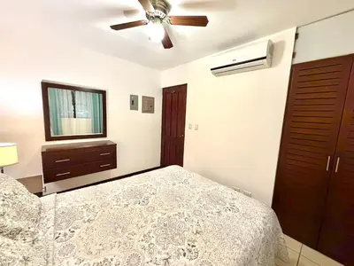 a bedroom with a bed and a ceiling fan at Cocomarindo Breeze Condo and Amazing Pool in Coco