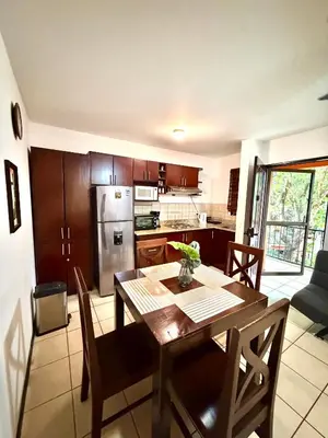 a kitchen and dining room with a table and a kitchen with a refrigerator at Cocomarindo Breeze Condo and Amazing Pool in Coco