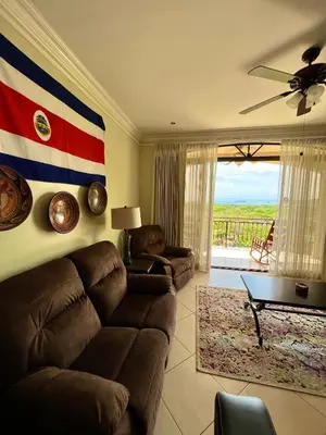 a living room with a couch and a flag on the wall at Oceanview Rancho with Two bedroom & Two baths in Coco