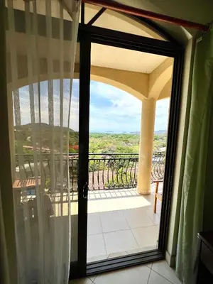 a sliding glass door with a view of a balcony at Oceanview Rancho with Two bedroom & Two baths in Coco
