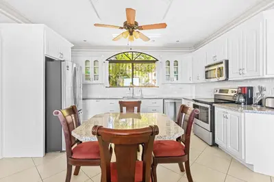 a kitchen with a table and chairs and a ceiling fan at Casa Blanca Two Bedroom,Two Bath Oceanview Condo in Coco