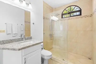 a bathroom with a shower and a toilet and a sink at Casa Blanca Two Bedroom,Two Bath Oceanview Condo in Coco
