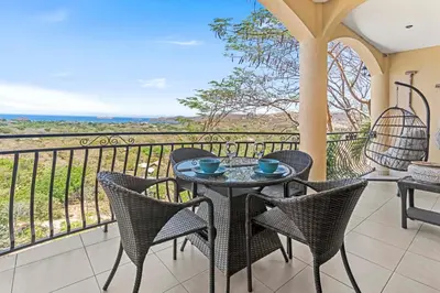 a patio with a table and chairs on a balcony at Casa Blanca Two Bedroom,Two Bath Oceanview Condo in Coco