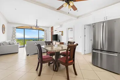 a kitchen and living room with a table and chairs at Casa Blanca Two Bedroom,Two Bath Oceanview Condo in Coco