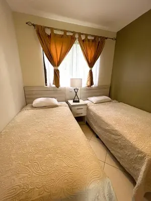 two beds in a bedroom with a window at Sunny Tropical condo and rooftop terrace in Coco