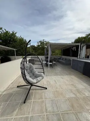 a rocking chair sitting on top of a roof at Sunny Tropical condo and rooftop terrace in Coco