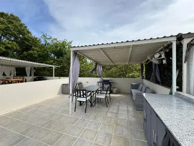 a patio with a table and chairs on a roof at Sunny Tropical condo and rooftop terrace in Coco