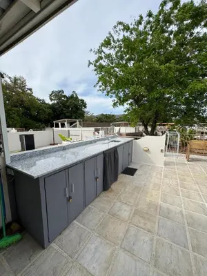 an outdoor kitchen with a counter top on a patio at Sunny Tropical condo and rooftop terrace in Coco