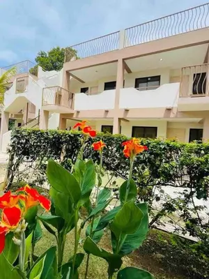 a building with red flowers in front of it at Coco Dream Escapes Ground unit in Coco